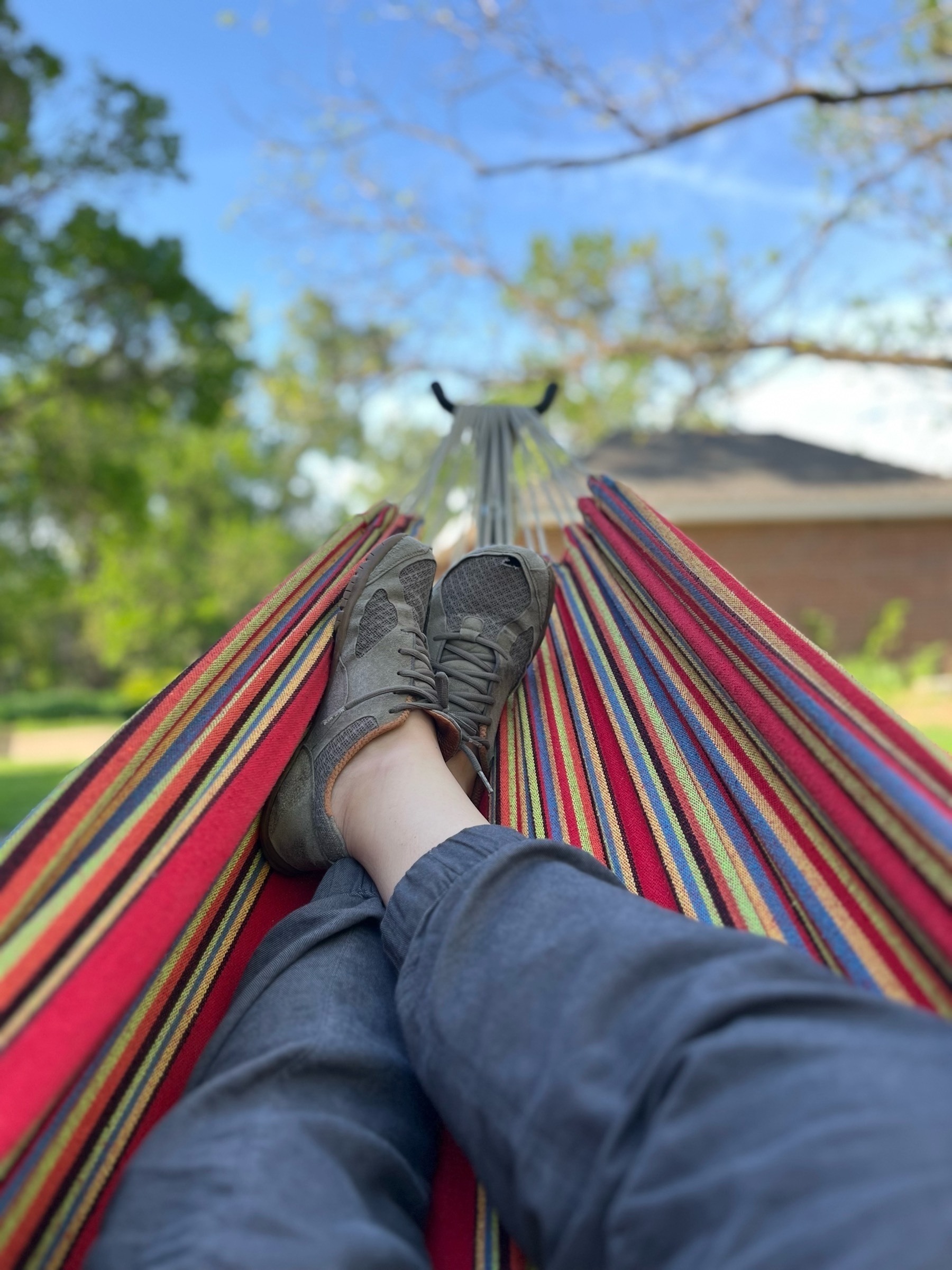 Photo of my feet as I lay down in a rainbow colored hammock. 
